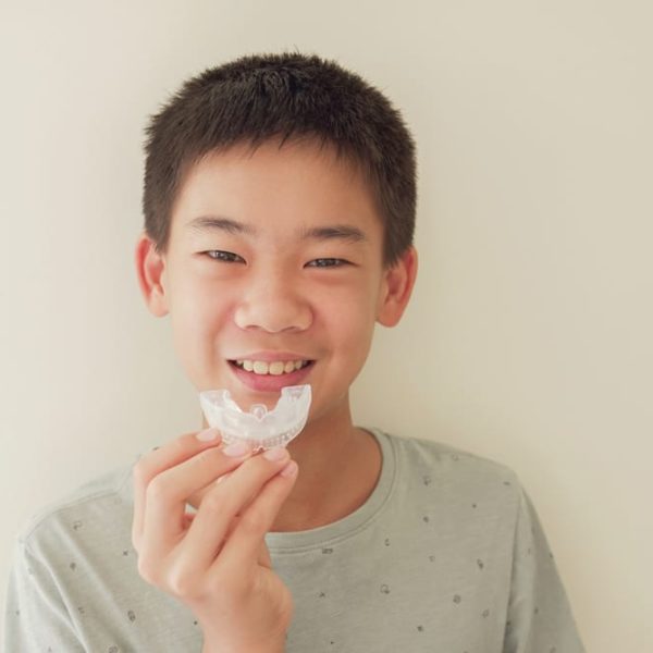 Smiling,Asian,Preteen,Boy,Holding,Invisalign,Braces,,Mouthguard,,Teen,Orthodontic